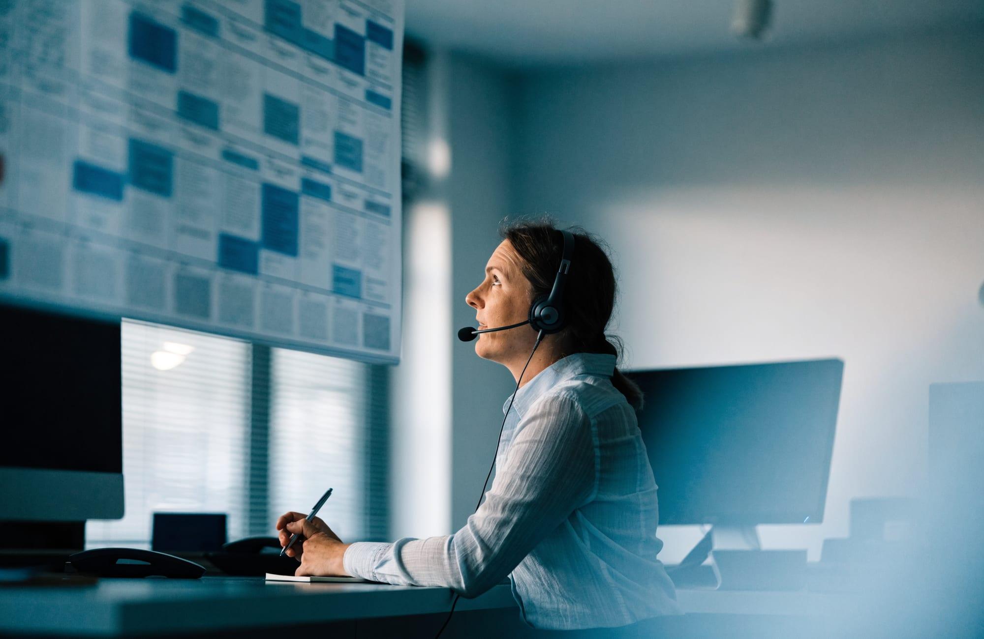 An authorization coordinator on a headset call at a desk
